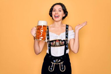 Mavi gözlü güzel Alman kadın geleneksel Ekim Festivali elbisesi giyiyor. Bira kavanozu içiyor. Çok mutlu ve heyecanlı.