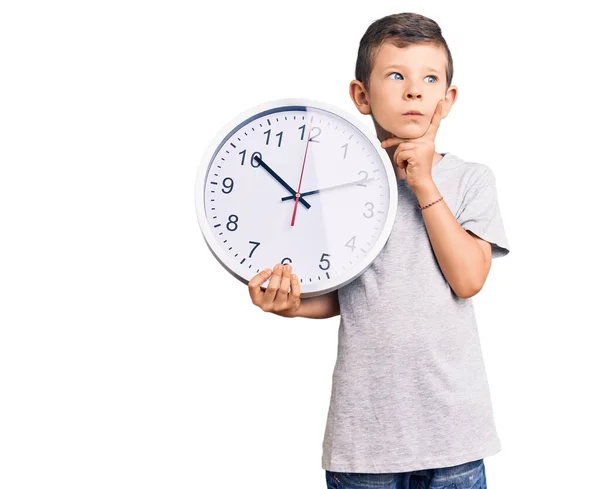 Cute Blond Kid Holding Big Clock Serious Face Thinking Question — Stock Photo, Image
