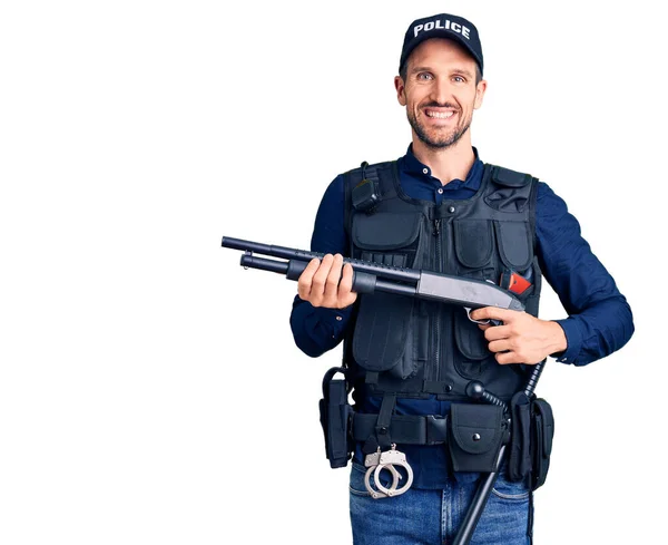 Joven Hombre Guapo Vistiendo Uniforme Policía Sosteniendo Escopeta Buscando Positivo —  Fotos de Stock
