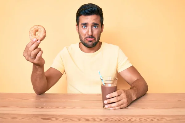 Νεαρός Ισπανός Κάθεται Στο Τραπέζι Πίνοντας Σοκολατένιο Ρόφημα Κρατώντας Ντόνατ — Φωτογραφία Αρχείου