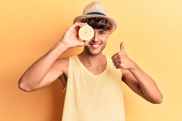Joven Hombre Hispano Sosteniendo Limón Sonriendo Feliz Positivo Pulgar Hacia — Foto de Stock
