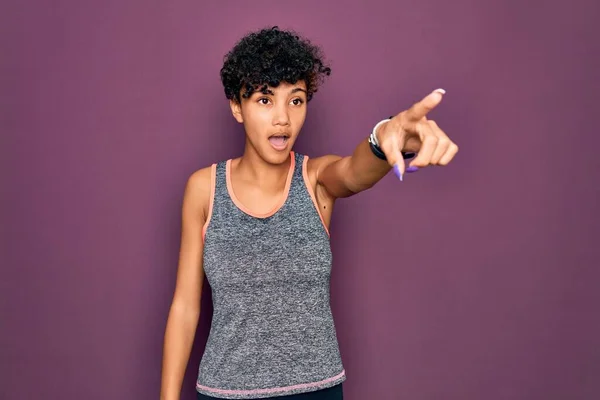 年轻美丽的非洲裔美国女运动员穿着运动服做运动 手指尖尖着前方 张开嘴惊讶的表情 前面有什么东西 — 图库照片