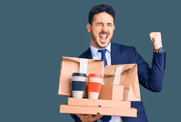 Jovem Hispânico Vestindo Terno Segurando Takeaway Café Comida Gritando Orgulhoso — Fotografia de Stock