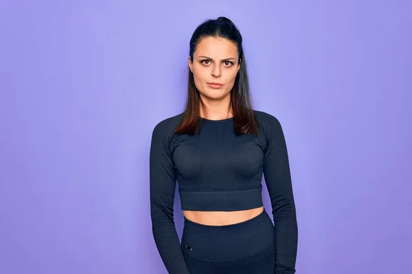 Young beautiful brunette sporty woman wearing casual sportswear over purple background skeptic and nervous, frowning upset because of problem. Negative person.