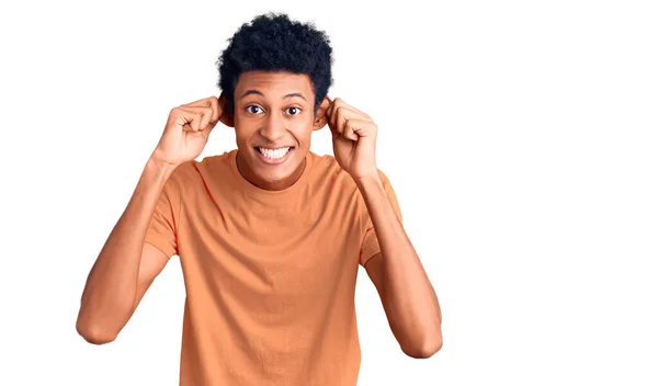 若いアフリカ系アメリカ人の男性は 指で耳を引く笑みを浮かべてカジュアルな服を着て 面白いジェスチャー オーディション問題 — ストック写真