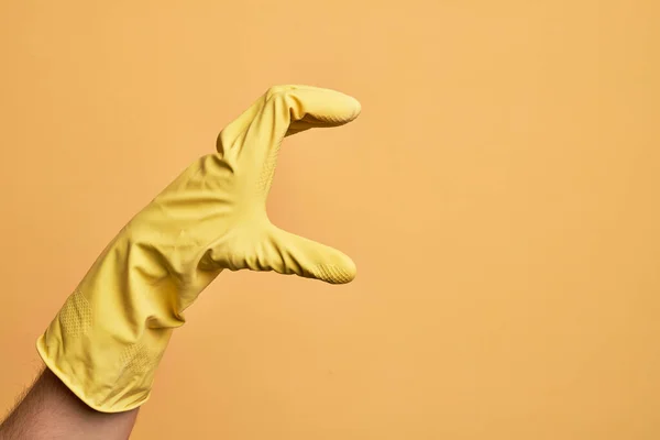 Mão Jovem Caucasiano Com Luva Limpeza Sobre Fundo Amarelo Isolado — Fotografia de Stock