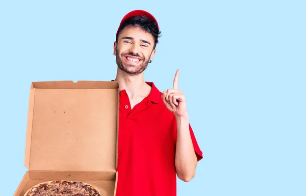 Young Hispanic Man Holding Delivery Pizza Box Surprised Idea Question — Stock Photo, Image