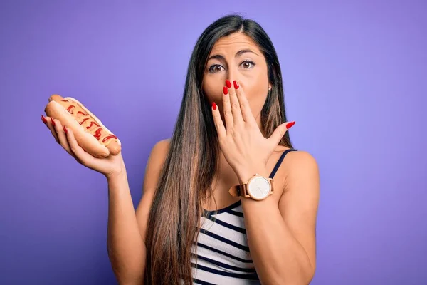 Jovem Comendo Cachorro Quente Com Ketchup Mostarda Sobre Fundo Roxo — Fotografia de Stock