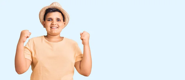 小男孩头戴夏帽 身穿夏威夷式泳衣 带着张开双臂和睁开眼睛庆祝胜利 感到惊讶和惊奇 获奖者概念 — 图库照片