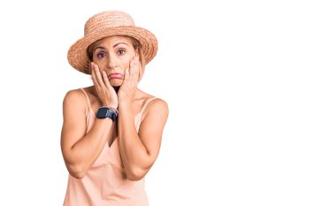 Yazlık şapkalı genç sarışın kadın yorgun eller yüzünü kapatıyor, depresyon ve üzüntü, sorun yüzünden üzgün ve sinirli. 