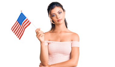Amerika Birleşik Devletleri bayrağını tutan genç ve güzel bir kadın. Düşünme tavrı ve ayık yüz ifadesi. Kendine güveniyor gibi görünüyor. 