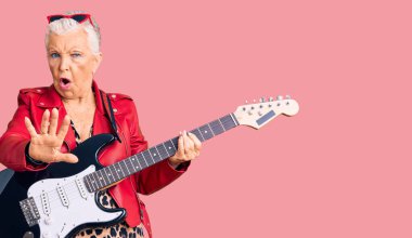 Son sınıf güzeli, mavi gözlü, gri saçlı, modern görünümlü, elektro gitar çalan, avuç içi hareketlerini durduran, sinirli ve hayal kırıklığına uğramış bir kadın. 