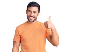 Neşeli ve pozitif gülümseyen İspanyol asıllı genç adam, mükemmel ve onay işareti yapıyor. 