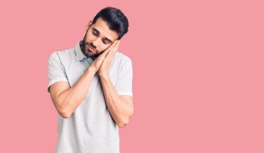 Sakallı, sıradan polo giyen, yorgun uyuyan, hayal kuran, elleri ve gözleri kapalı gülümseyen genç yakışıklı bir adam.. 