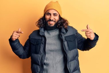 Gündelik kışlık giysiler giyen genç bir Arap. Kendine güvenen, gülümseyen, kendini gururlu ve mutlu gösteren bir adam.. 