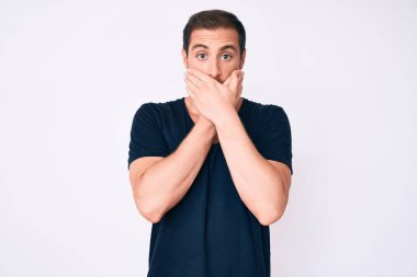 Gündelik giysiler giyen genç yakışıklı adam yanlışlıkla elleri ile ağzını kapatırken şok oldu. gizli kavram. 
