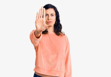 Gündelik kıyafetler giyen genç, güzel İspanyol kadın avucuyla şarkı söylemeyi kesiyor. Yüzünde olumsuz ve ciddi bir jest olan uyarı ifadesi. 