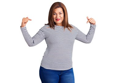 Orta yaşlı, gündelik kıyafetler giyen, kendine güvenen, gülümseyen, kendini gururlu ve mutlu gösteren Latin bir kadın.. 