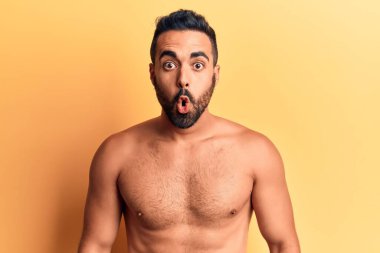 Genç İspanyol adam üstsüz duruyor. Korkmuş ve ağzı açık, şaşırmış ve şaşırmış. 
