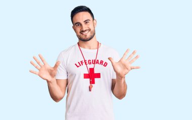 Cankurtaran üniforması giyen genç yakışıklı adam on numarayı gösterip işaret ederken kendinden emin ve mutlu bir şekilde gülümsüyor.. 