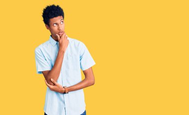 Gündelik giysiler giyen genç Afro-Amerikan bir soru hakkında endişeli ve gergin bir şekilde düşünüyor. 