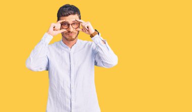 Zarif iş gömleği ve gözlük takan yakışıklı genç adam parmaklarıyla gözlerini açmaya çalışıyor, uykulu ve yorgun sabah yorgunluğu çekiyor. 