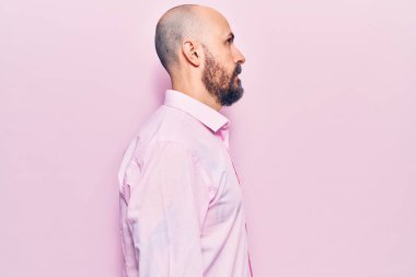 İş kıyafetleri giyen genç yakışıklı bir adam, rahat bir görünüm takınıyor, kendine güvenen bir gülümsemeyle doğal bir yüz ifadesi takınıyor.. 