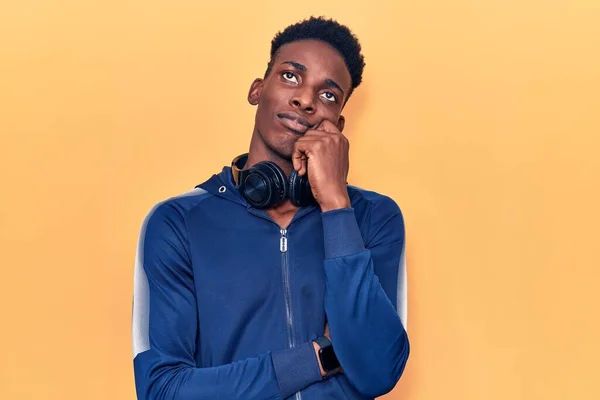 Νεαρός Αφροαμερικάνος Άντρας Που Φοράει Αθλητικά Και Ακουστικά Σκέφτεται Συγκεντρωμένα — Φωτογραφία Αρχείου