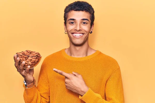 Jonge Afrikaans Amerikaanse Man Met Een Schaal Met Amandelen Glimlachend — Stockfoto