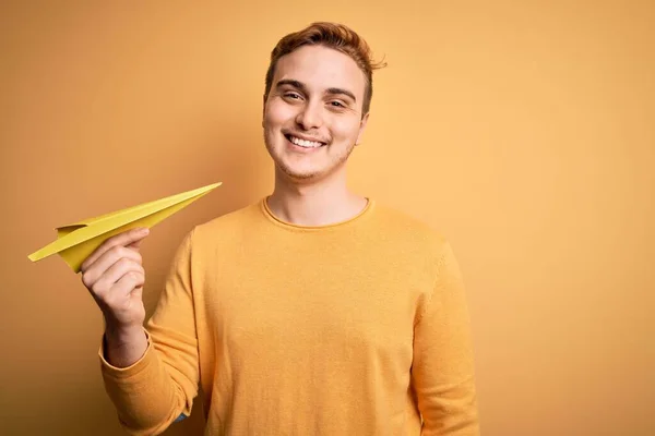 Homem Ruivo Bonito Jovem Segurando Avião Papel Sobre Fundo Amarelo — Fotografia de Stock