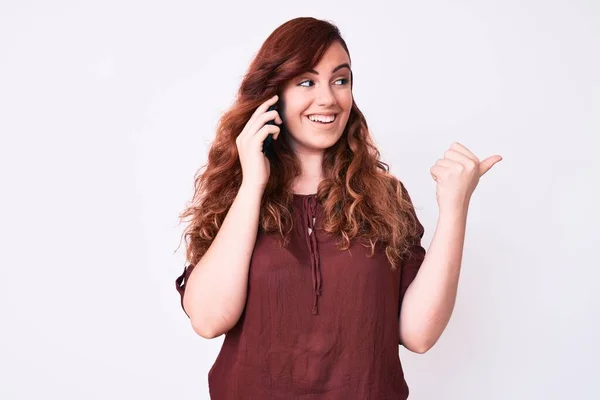 Young Beautiful Woman Having Conversation Talking Smartphone Pointing Thumb Side — Stock Photo, Image