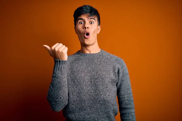 Junger Gutaussehender Mann Lässigem Pullover Vor Isoliertem Orangefarbenem Hintergrund Überrascht — Stockfoto