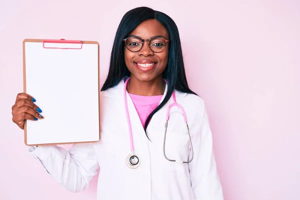 Young African American Woman Wearing Doctor Stethoscope Holding Clipboard Looking — Stock Photo, Image