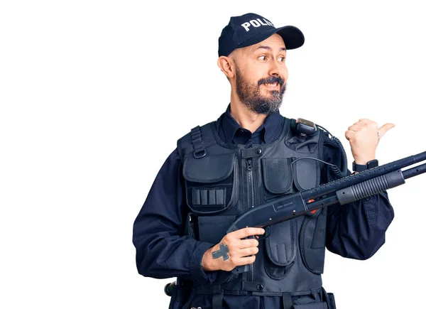 Young Handsome Man Wearing Police Uniform Holding Shotgun Pointing Thumb — Stock Photo, Image