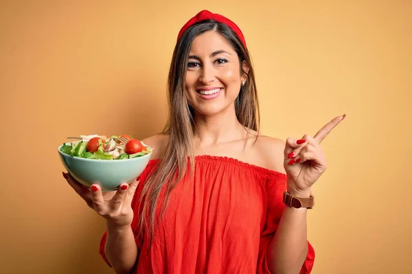 Junge Schöne Brünette Frau Isst Gesunden Salat Über Isolierten Gelben — Stockfoto