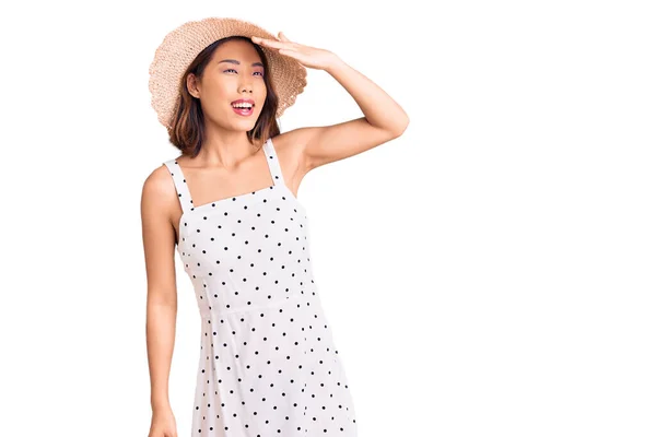 若い美しい中国の女の子は夏の帽子をかぶって非常に幸せと笑みを浮かべて遠くを見て頭の上に手で 検索の概念 — ストック写真