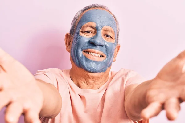 Starszy Mężczyzna Siwymi Włosami Masce Błotnej Patrzący Kamerę Uśmiechający Się — Zdjęcie stockowe