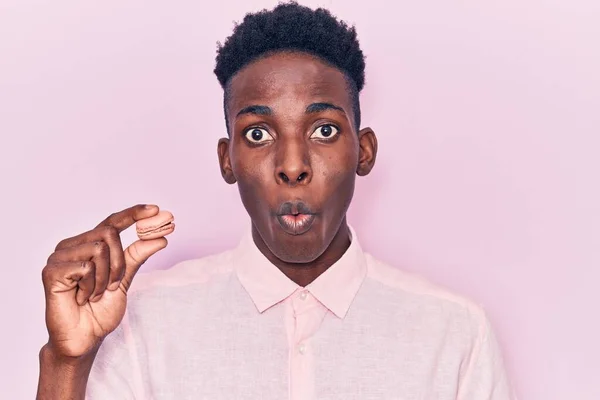 Joven Hombre Afroamericano Sosteniendo Macaron Asustado Sorprendido Con Boca Abierta — Foto de Stock