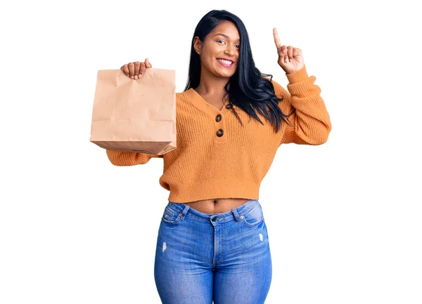 Mujer Hispana Con Cabello Largo Sosteniendo Llevar Bolsa Papel Sorprendida —  Fotos de Stock