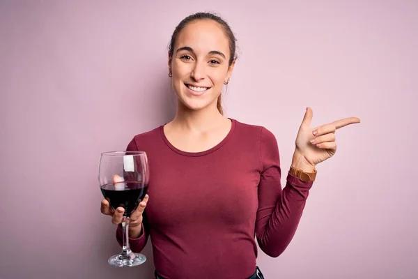 Młoda Piękna Kobieta Pije Kieliszek Czerwonym Winem Odizolowanym Różowym Tle — Zdjęcie stockowe