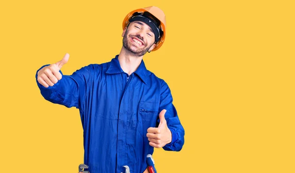 Jovem Hispânico Vestindo Uniforme Trabalhador Aprovando Fazer Gesto Positivo Com — Fotografia de Stock