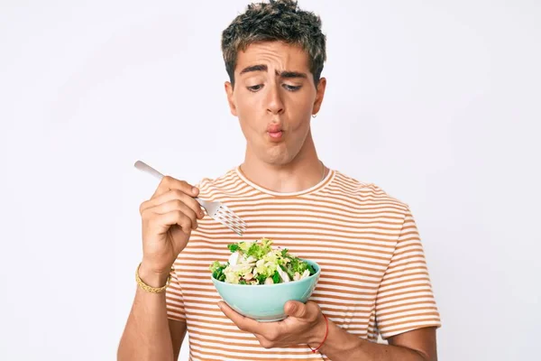 Young Handsome Man Eating Salad Making Fish Face Mouth Squinting — Stock Photo, Image