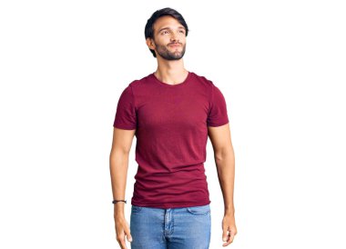 Yakışıklı İspanyol bir adam günlük kıyafetler giyiyor gülümsüyor ve yan tarafa bakıyor ve düşünüyor.. 