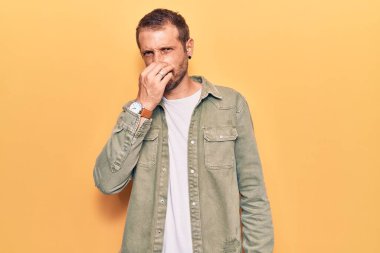 Sıradan kıyafetler giyen genç yakışıklı bir adam pis ve iğrenç bir koku alıyor, dayanılmaz bir koku, nefesini burnunda tutuyor. Kötü kokuyor. 