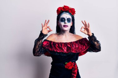 Meksika usulü makyaj yapan genç bir kadın rahatlamış ve parmaklarıyla meditasyon hareketi yaparken gözleri kapalı gülümsüyordu. yoga konsepti. 