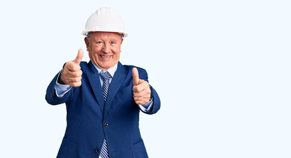 スーツを着たシニアハンサムな白髪の男と建築家のハードハットは 手で肯定的なジェスチャーを行うことを承認し 親指を上げて笑顔と成功のために幸せ 勝者のジェスチャー — ストック写真