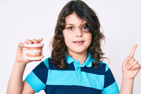 Lindo Niño Hispano Con Pelo Largo Sosteniendo Dentadura Postiza Sonriendo —  Fotos de Stock