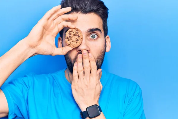 Young Handsome Man Beard Holding Chocolate Cookie Covering Mouth Hand — Stock Photo, Image