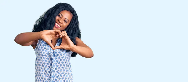 美丽的非洲裔美国女人穿着休闲的夏装 带着爱的笑容用手做着心形符号 浪漫的概念 — 图库照片