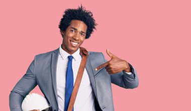 Yakışıklı Afro saçlı, mimar şapkalı, mutlu ve gururlu bir kendini gösteren Afro-Amerikan erkeği. 